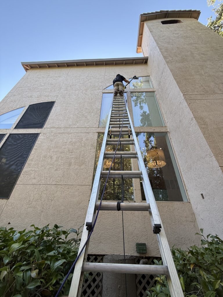 Reaching second-story glass from the ladder
